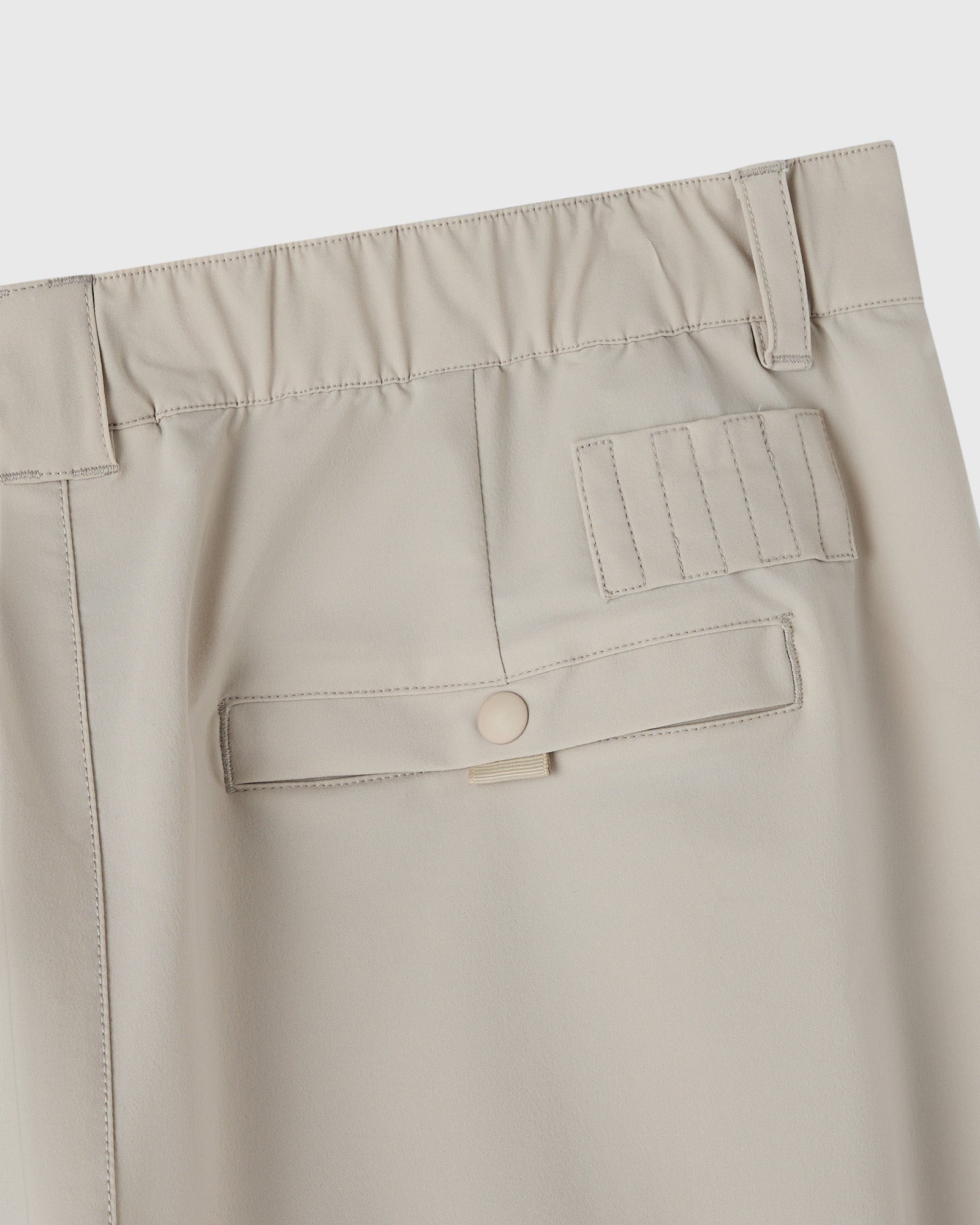 Sandstone chino pants with visible waistband, belt loops, cargo pockets, and stitched details.