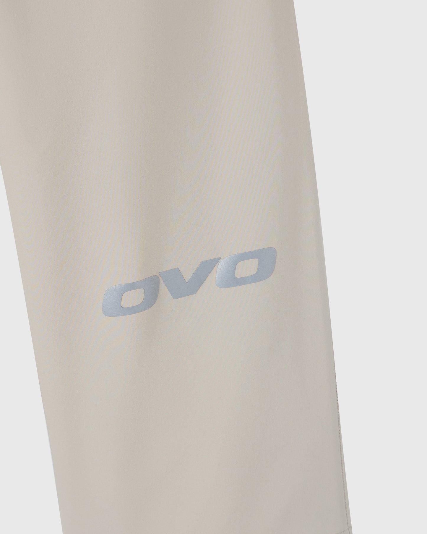 Sandstone-colored stretch nylon chino pants with OVO logo printed on thigh.