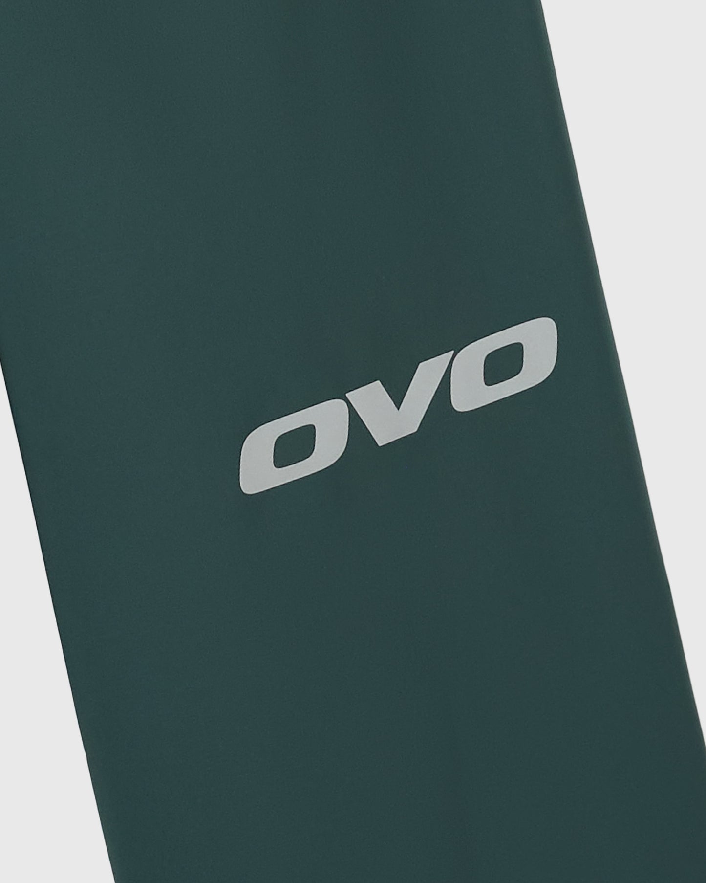 Midnight green chino pants with OVO logo printed on the leg.