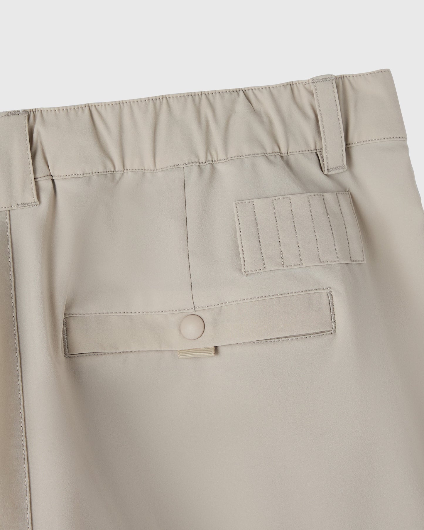Sandstone stretch nylon golf shorts with elastic waistband, utility pocket, and belt loop detail.