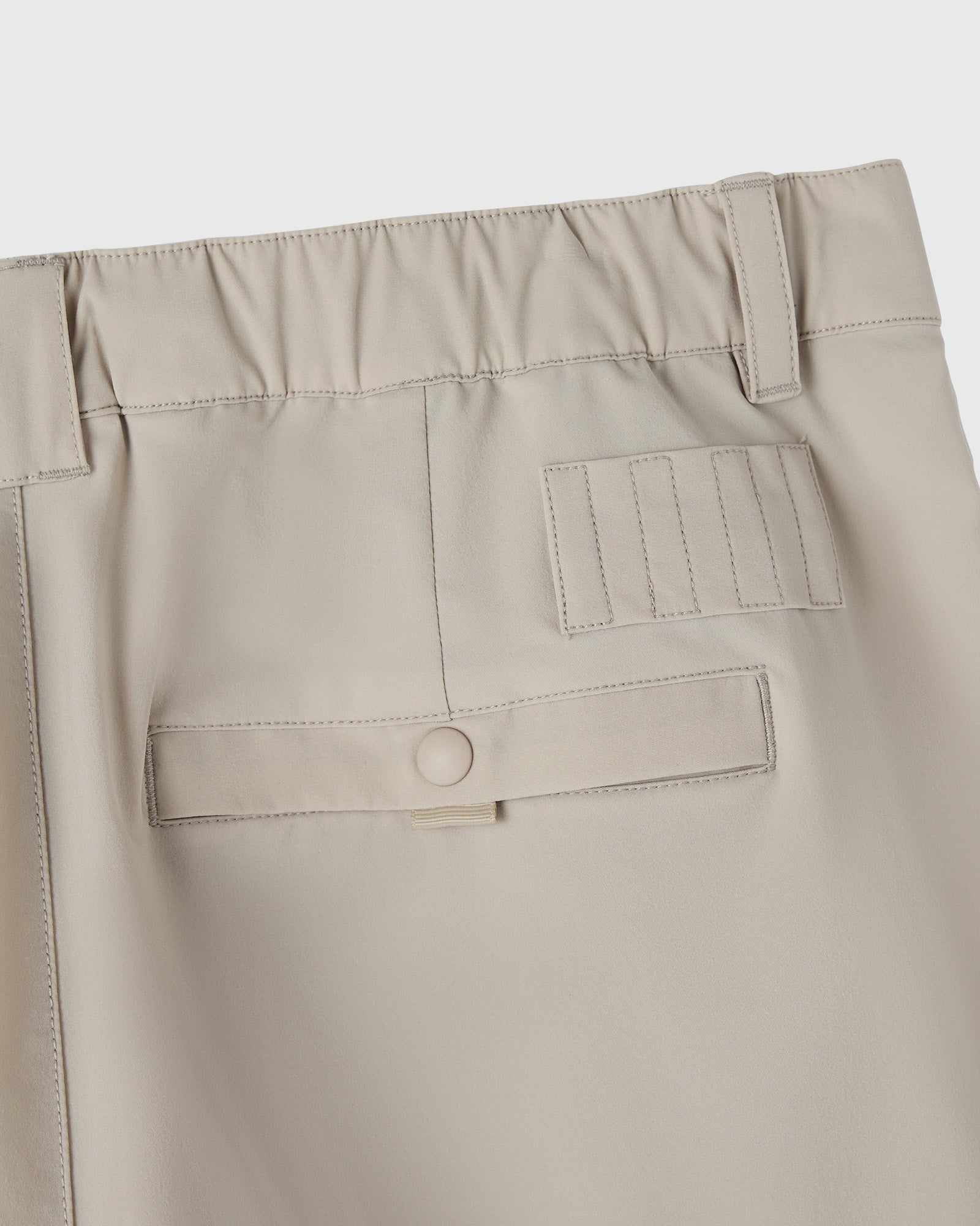 Sandstone stretch nylon golf shorts with elastic waistband, utility pocket, and belt loop detail.