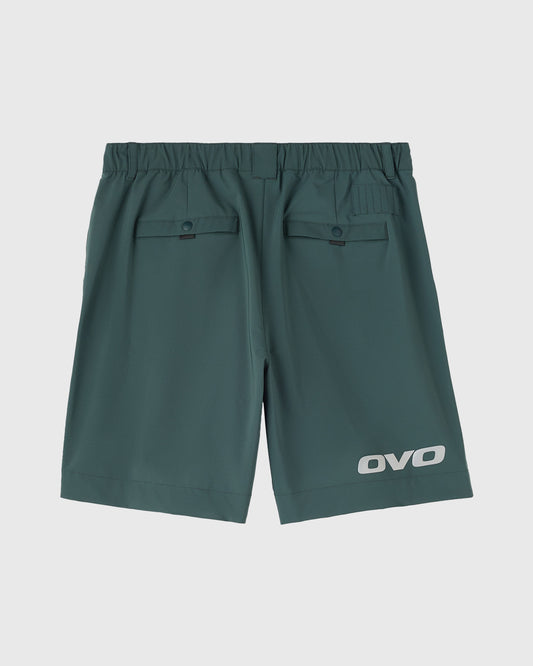 Midnight green golf shorts with elastic waistband, back flap pockets, and OVO logo on leg.