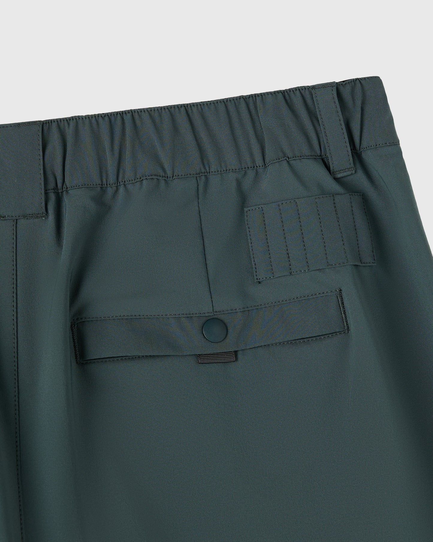 Midnight green golf shorts with elastic waistband, cargo pockets, and button closure detail.