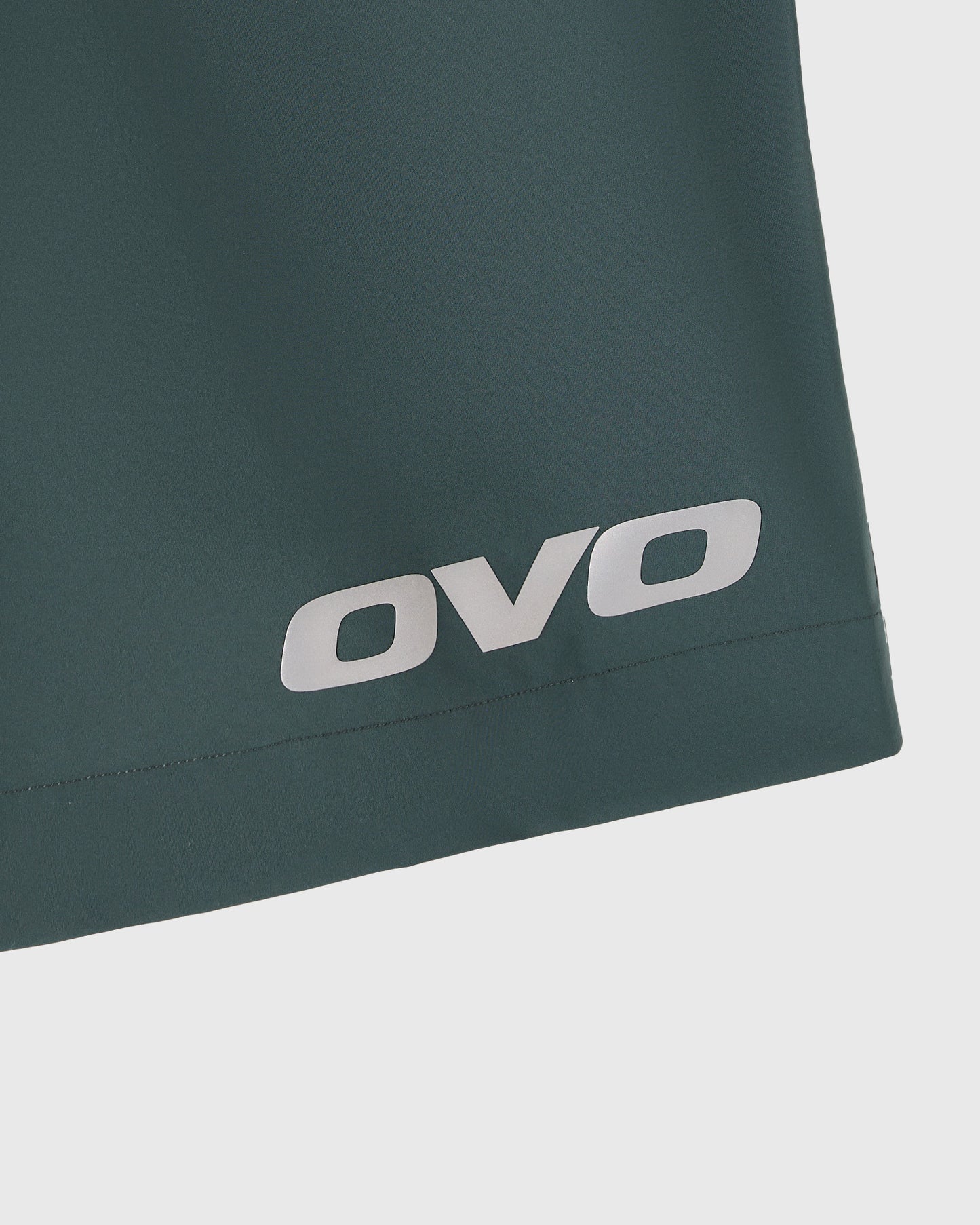 Midnight green golf short with white OVO logo on thigh.