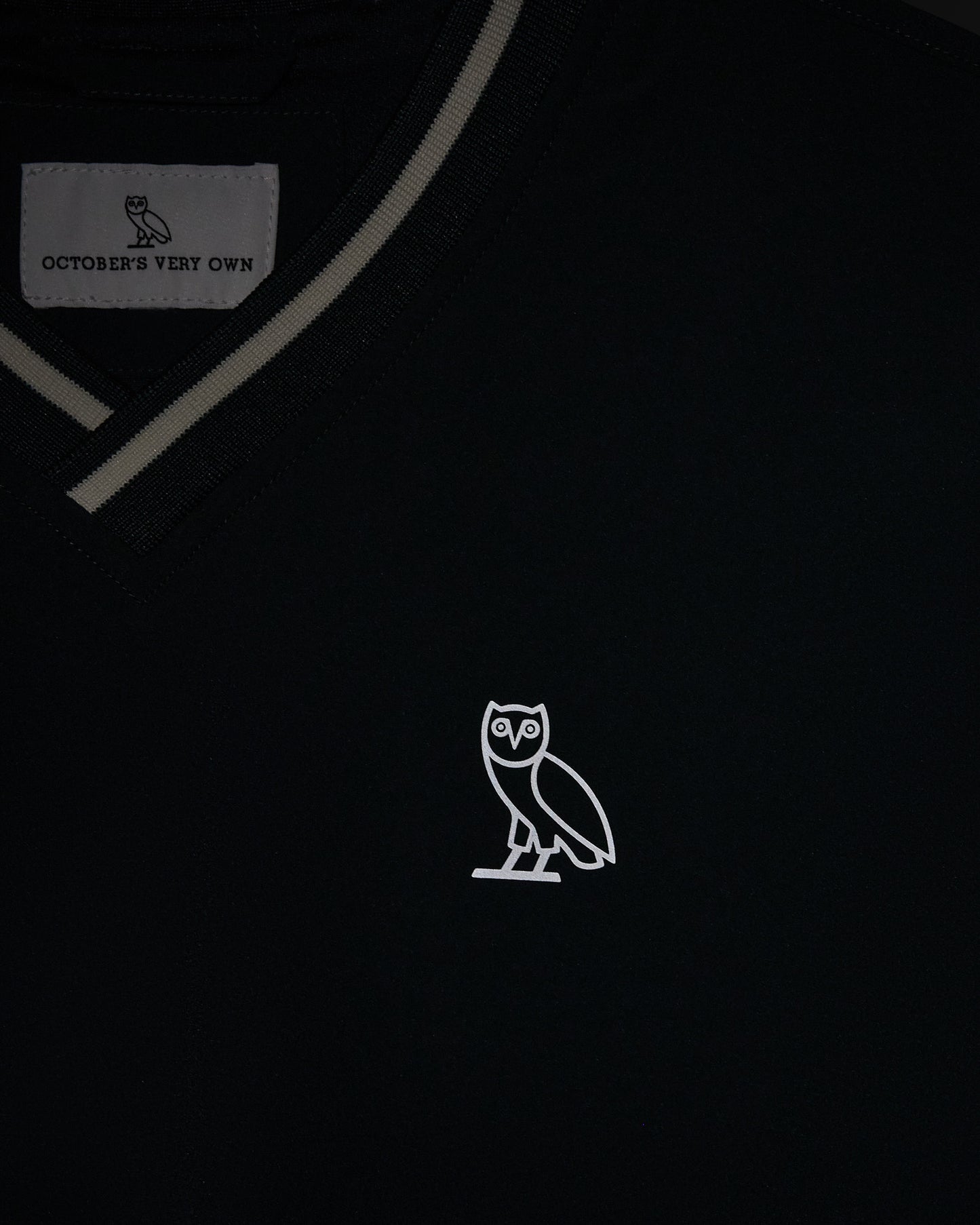 Midnight green V-neck pullover with gray trim detailing and white owl embroidery on chest.