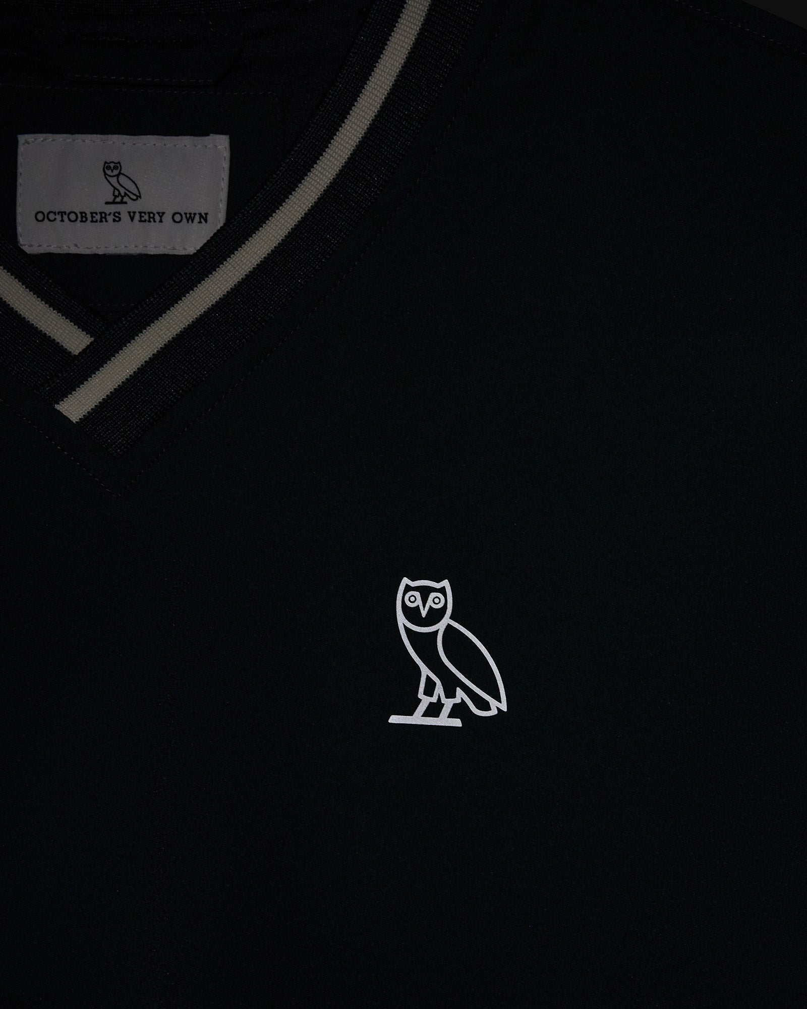 Midnight green V-neck pullover with gray trim detailing and white owl embroidery on chest.