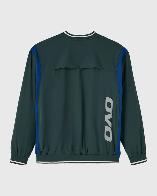 Midnight green pullover with blue side panels, white striping at neckline and cuffs, and OVO logo on back.