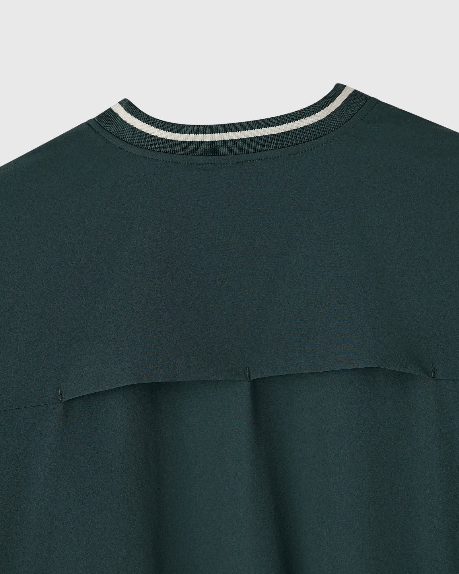 Midnight green stretch nylon pullover with white stripe trim at crew neckline and horizontal seam detail across chest.