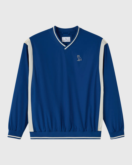 Deep denim V-neck pullover with cream side panels and striped trim, featuring small owl logo on chest.