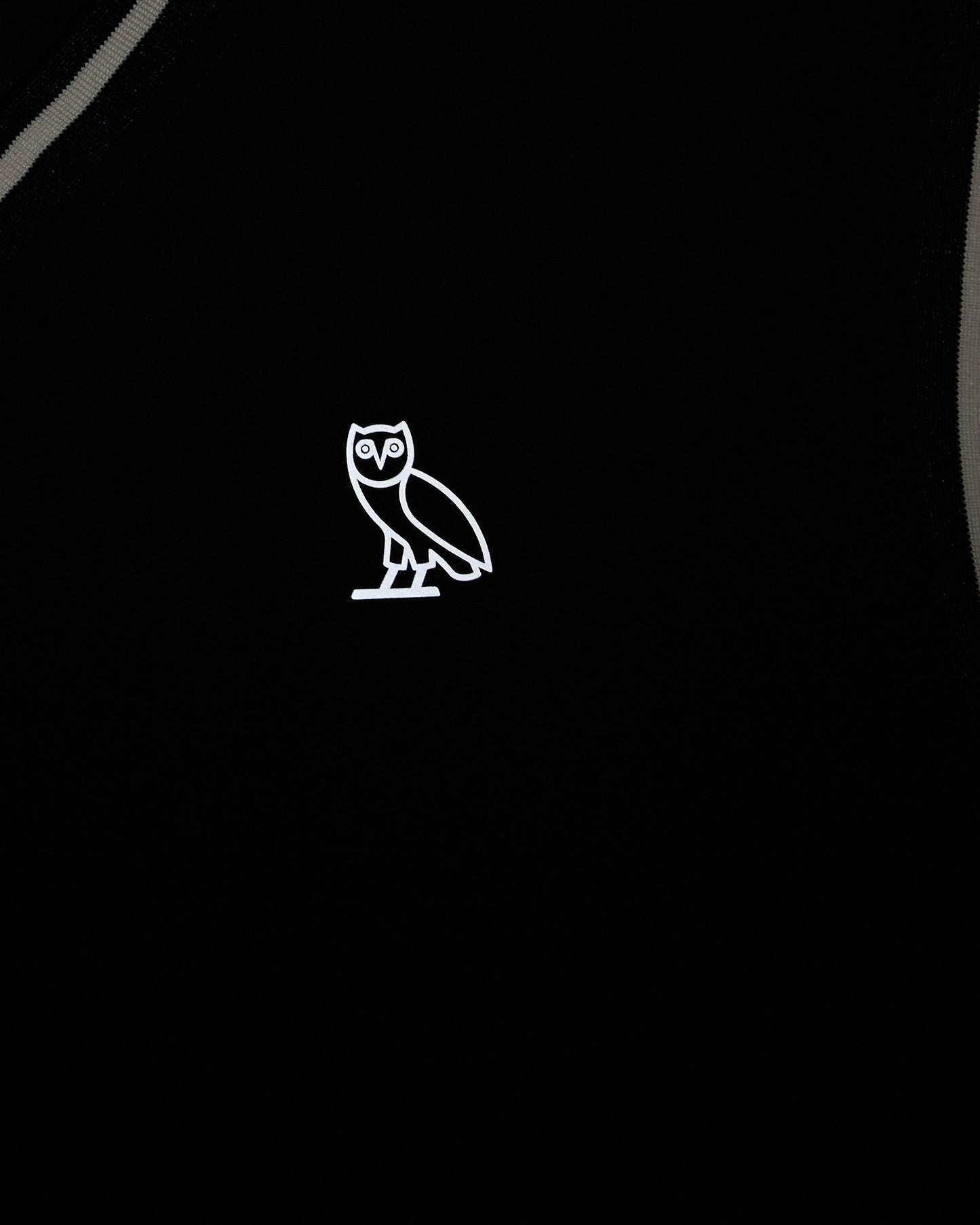 Black stretch nylon pullover vest with white owl logo on chest and gray trim details.