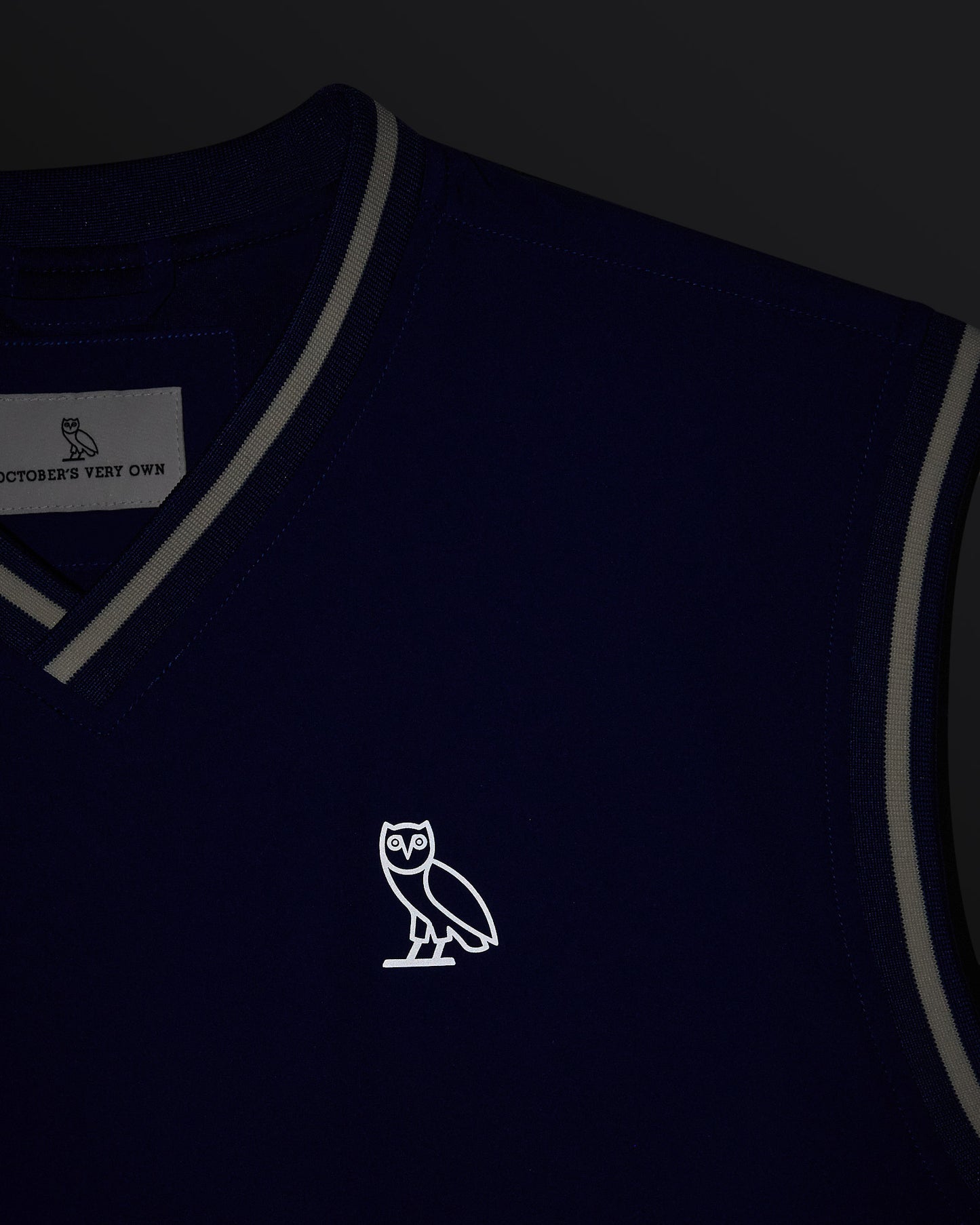 Deep denim pullover vest with gray trim and OVO owl logo on chest.