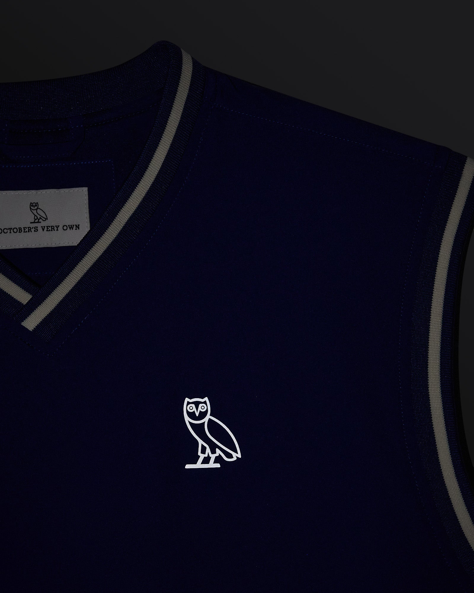 Deep denim pullover vest with gray trim and OVO owl logo on chest.