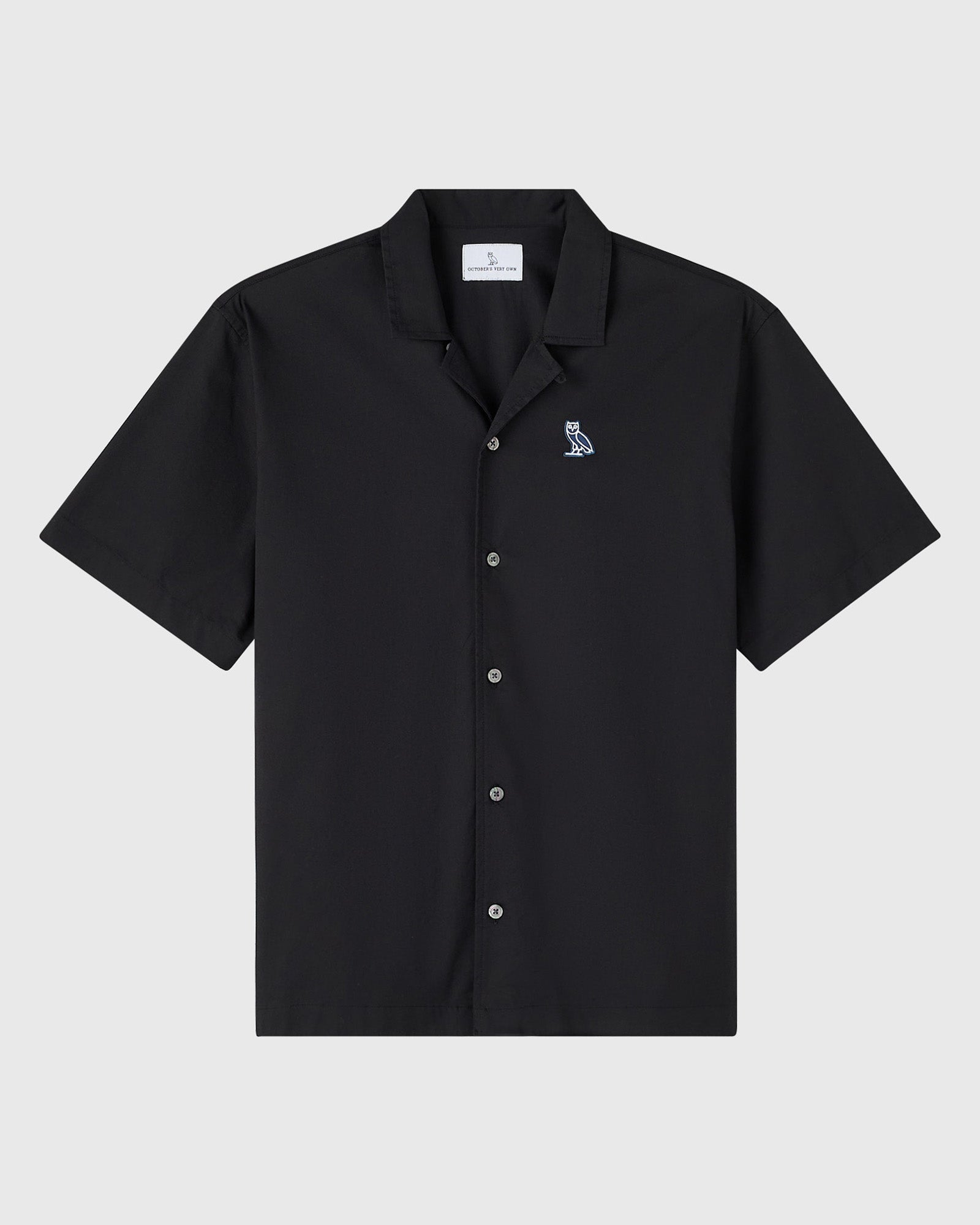 Black camp shirt with short sleeves, collared neckline, front button closure, and small owl emblem on chest.