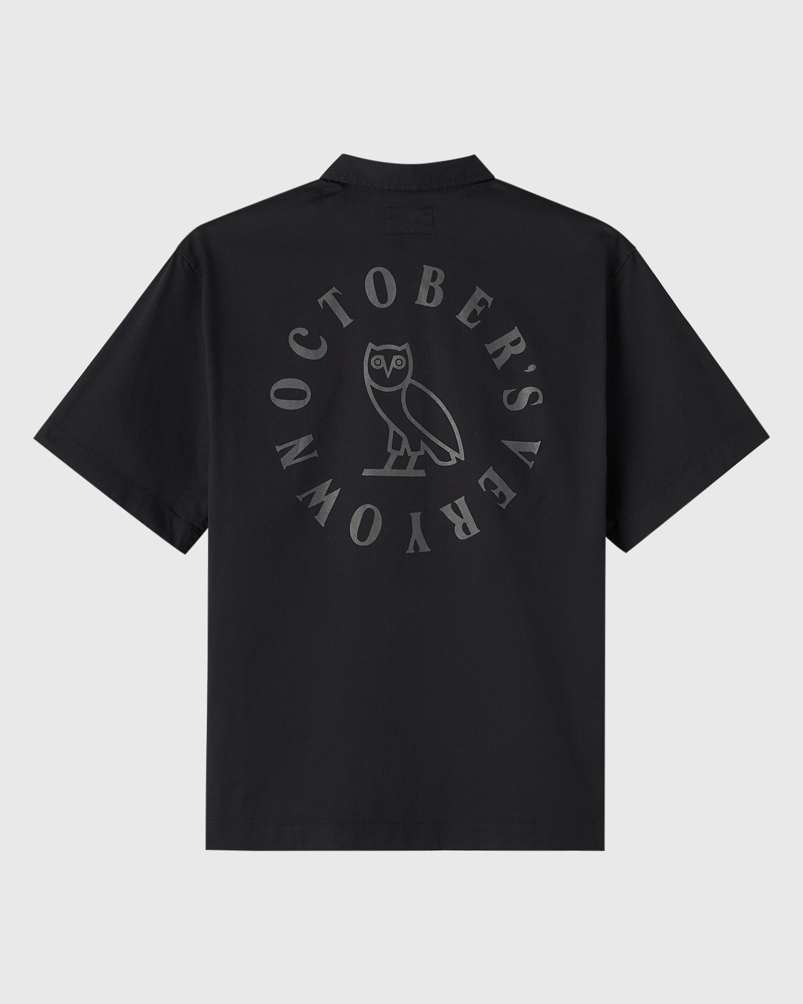Black camp shirt with circular wordmark and owl graphic printed on back.