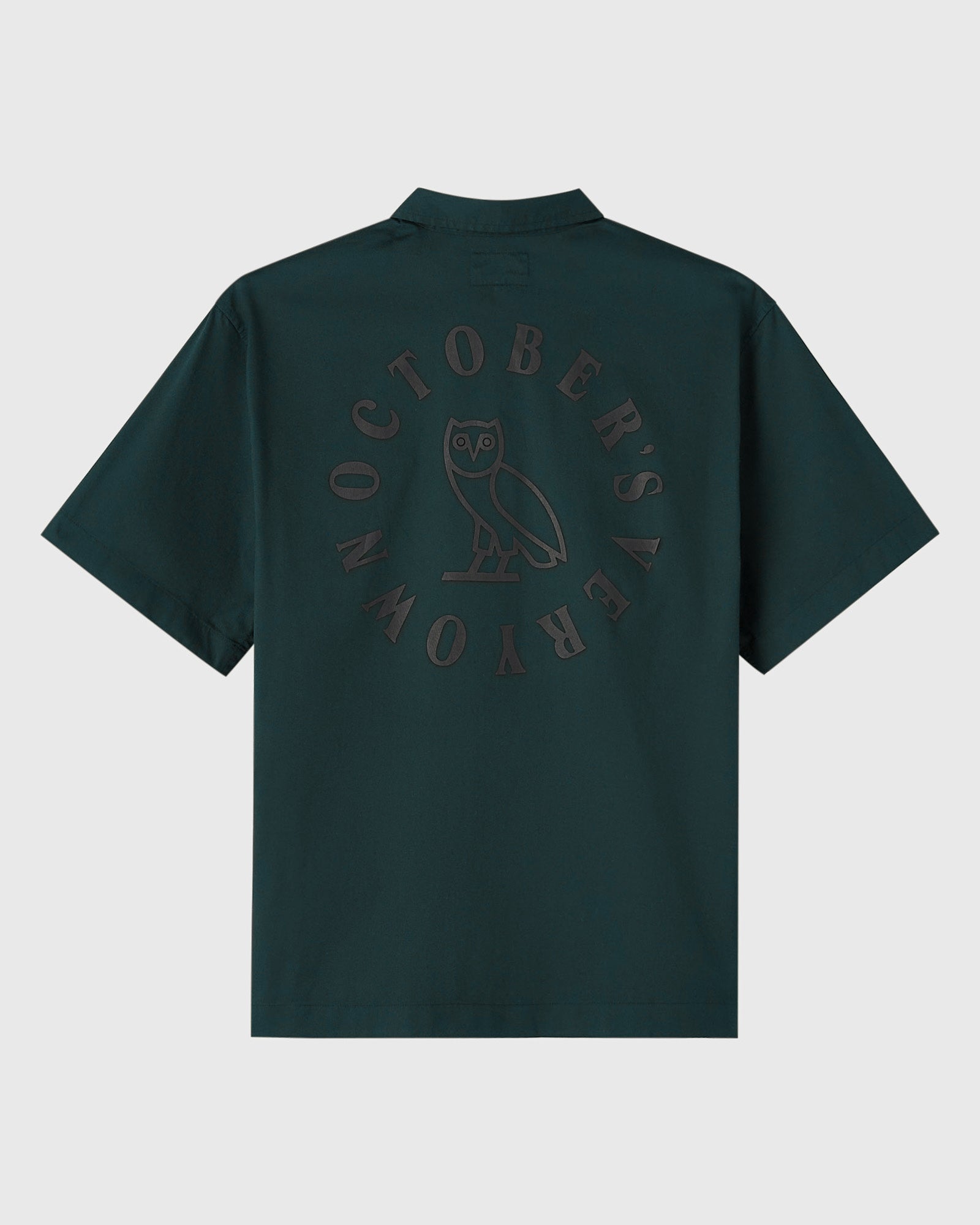 Midnight green camp shirt with circular owl wordmark graphic on back.