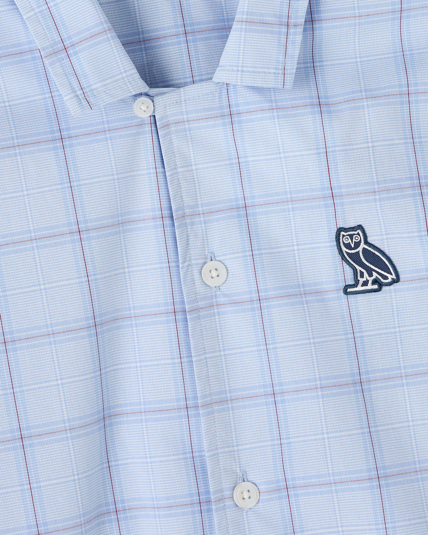 Light blue camp shirt with red and white grid pattern, white buttons, and embroidered owl logo on chest.