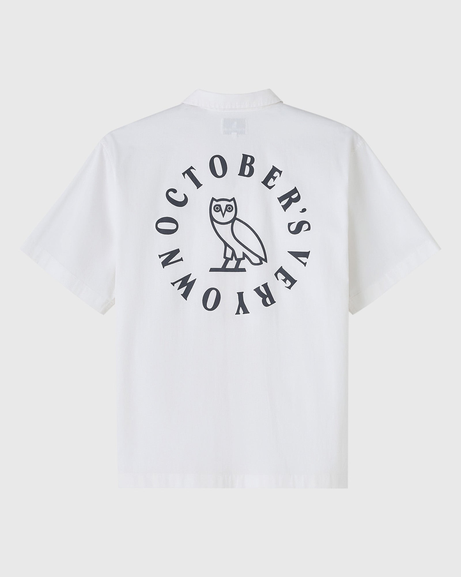 White camp shirt with circular back graphic featuring an owl and text reading "October's Rara" in dark print.