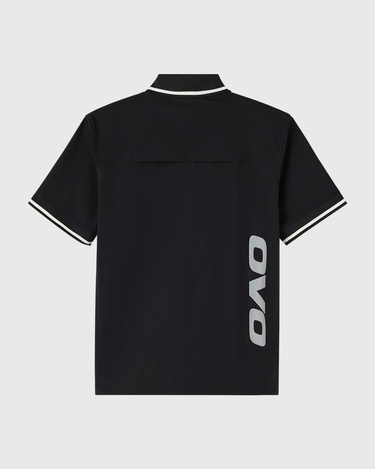 Black polo shirt with white stripe trim on collar and sleeves, OVO logo on side.