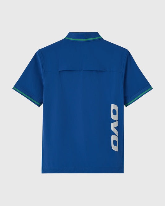 Deep denim blue polo shirt with green tipping on collar and sleeves, OVO logo on chest.