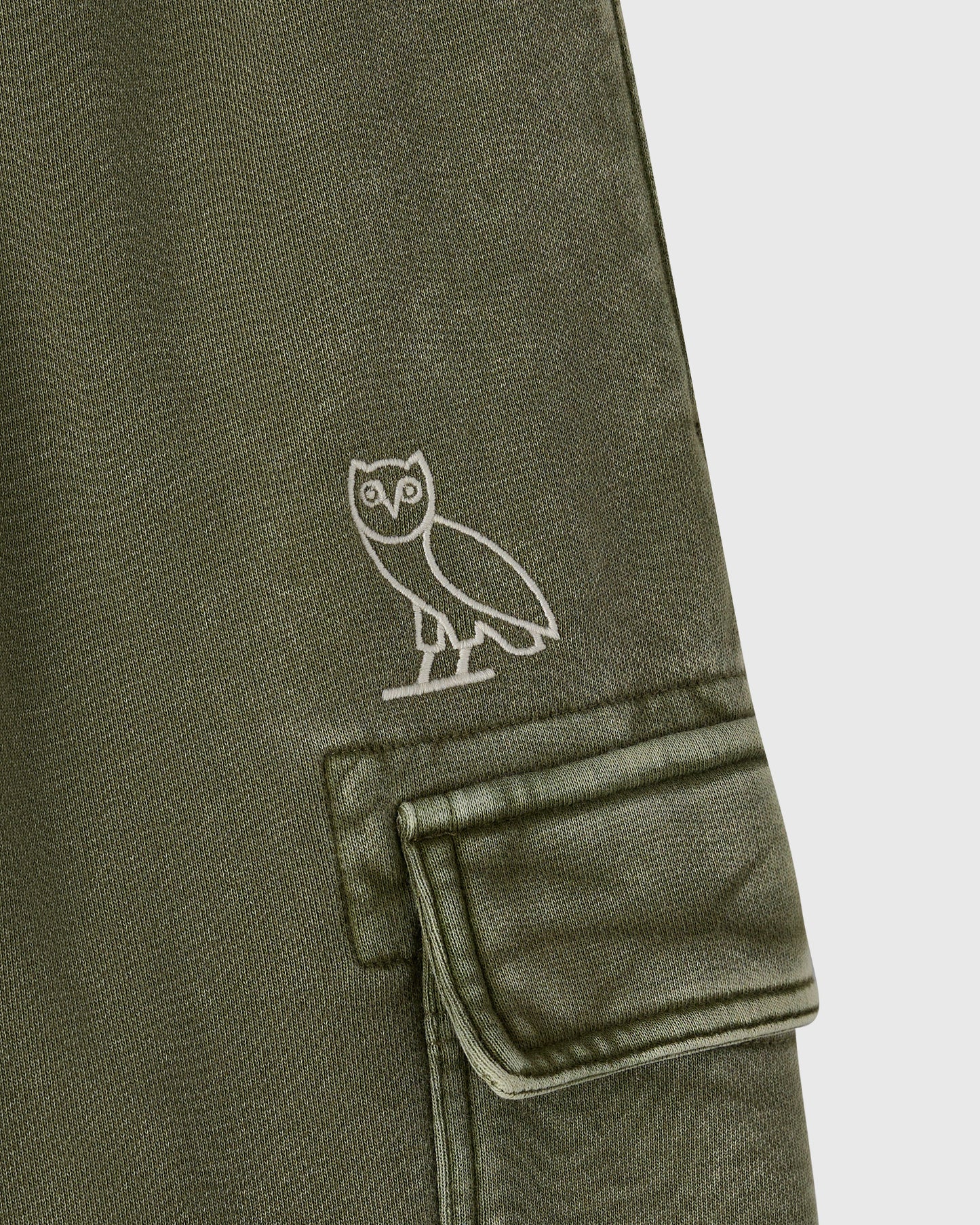 Cypress green cargo sweatpant with white owl embroidery on thigh and a cargo pocket with flap.
