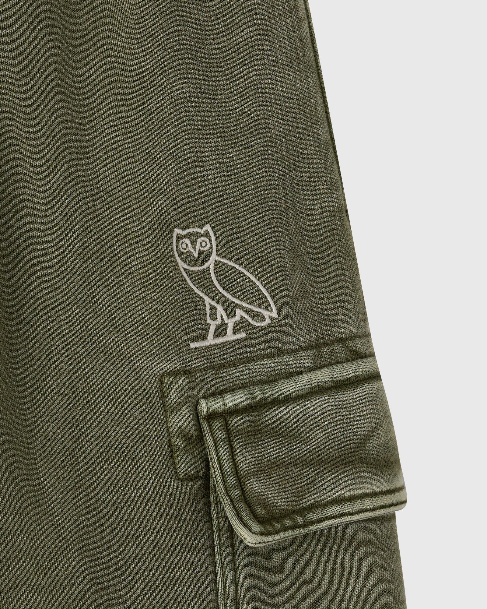 Cypress green cargo sweatpant with white owl embroidery on thigh and a cargo pocket with flap.