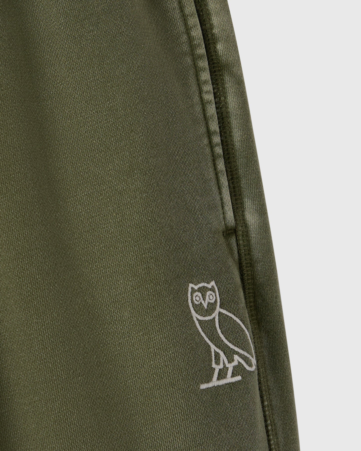 Cypress green sweatpant with white owl embroidery on the leg and drawstring waistband.