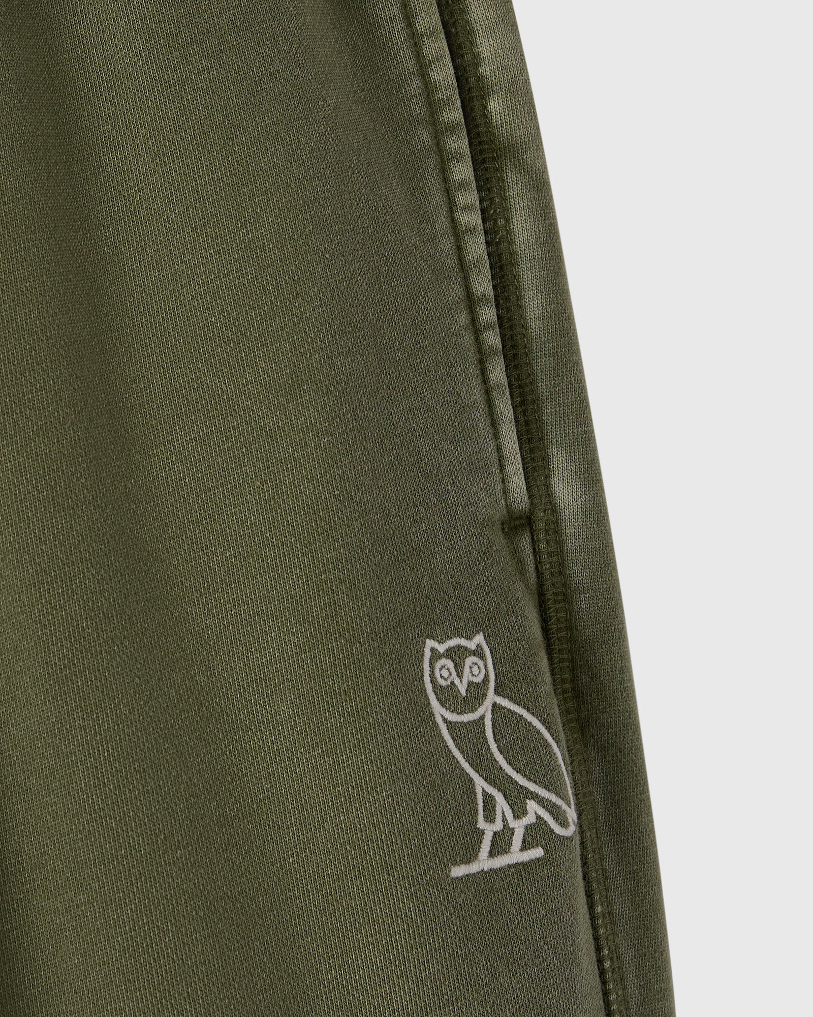 Cypress green sweatpant with white owl embroidery on the leg and drawstring waistband.