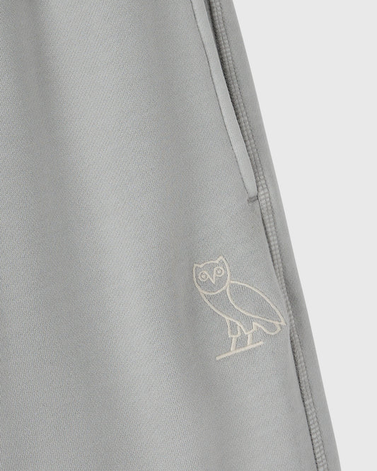 Gray sweatpant with embroidered owl logo and side seam detail.