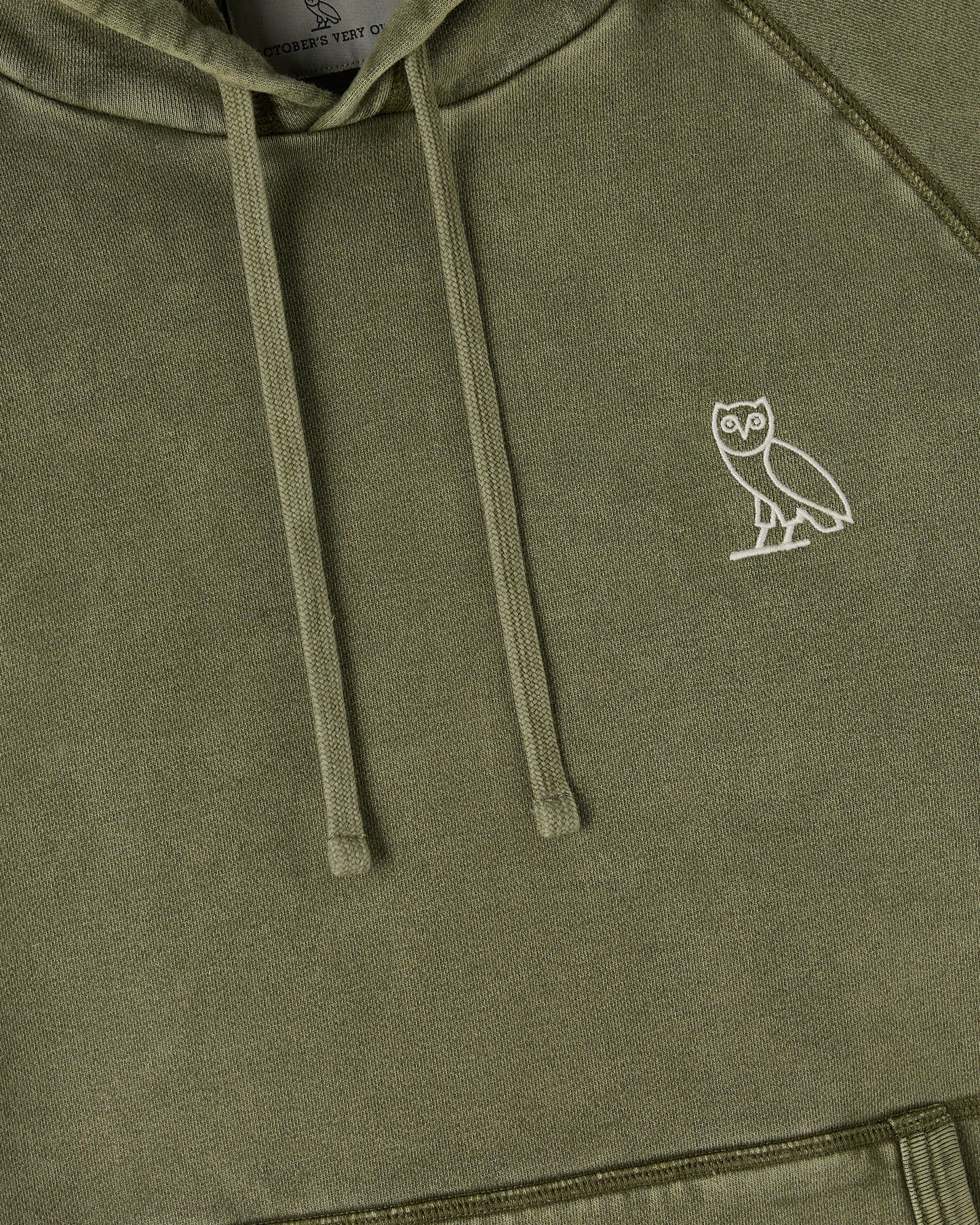 Cypress green raglan hoodie with white owl embroidery on chest and drawstring hood.