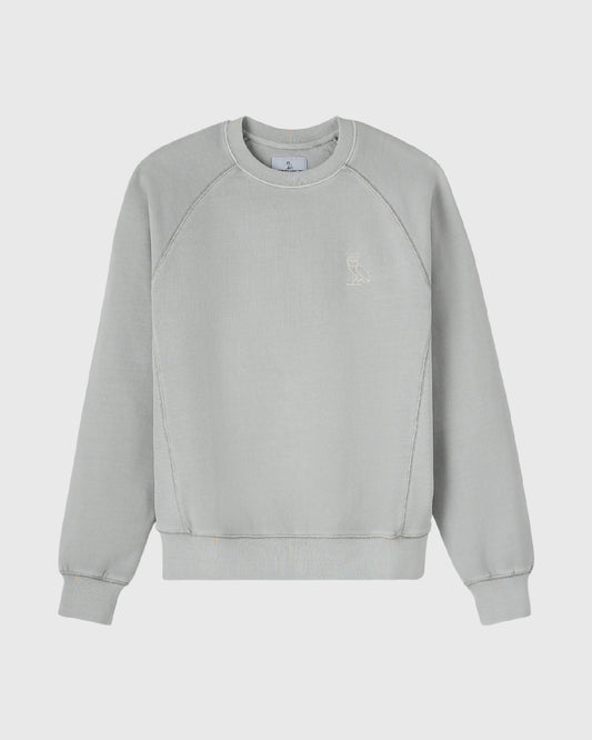 Gray crewneck sweatshirt with raglan sleeves and small embroidered owl logo on chest.