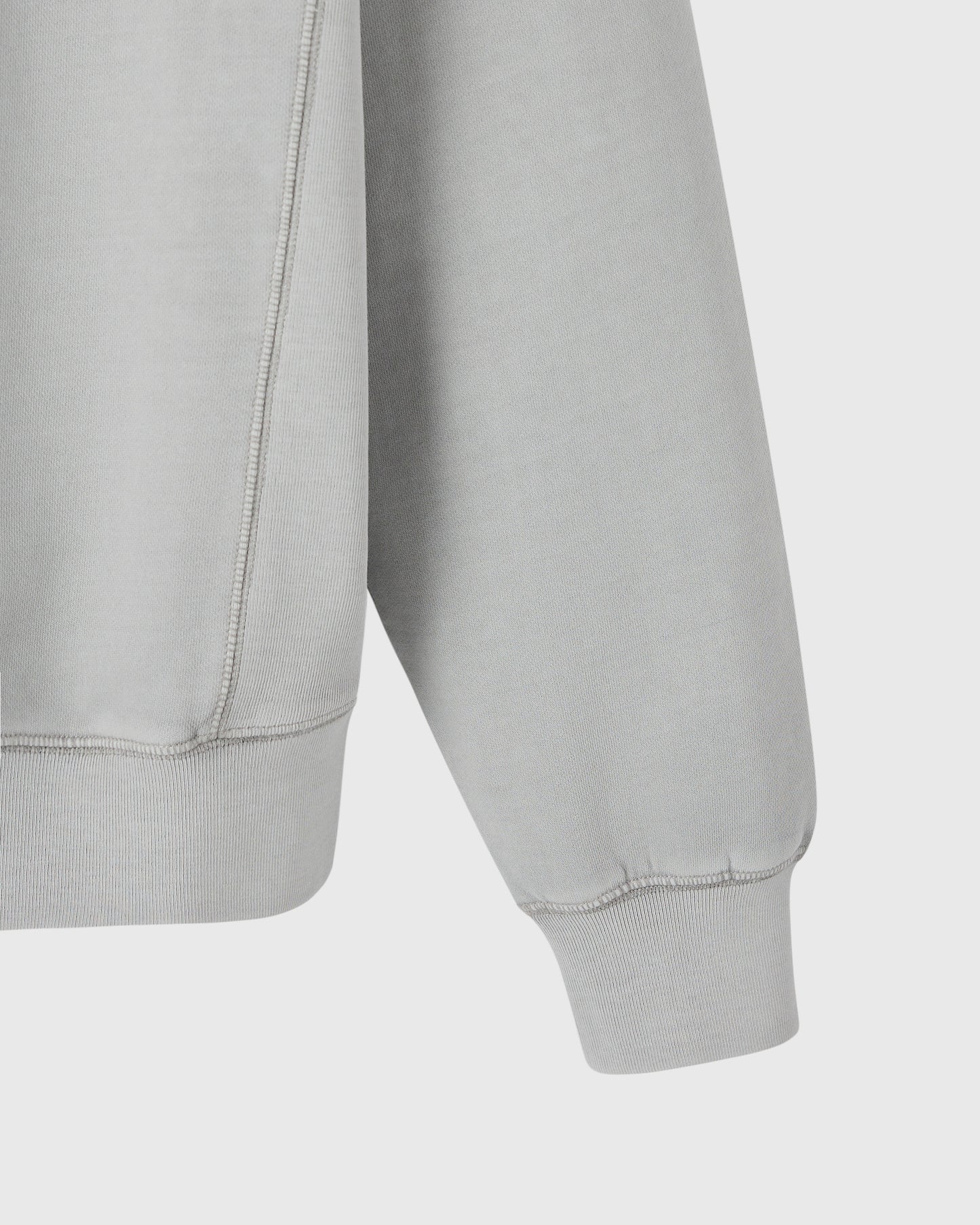 Gray crewneck sweatshirt with ribbed cuffs and hem, shown from side detail view.