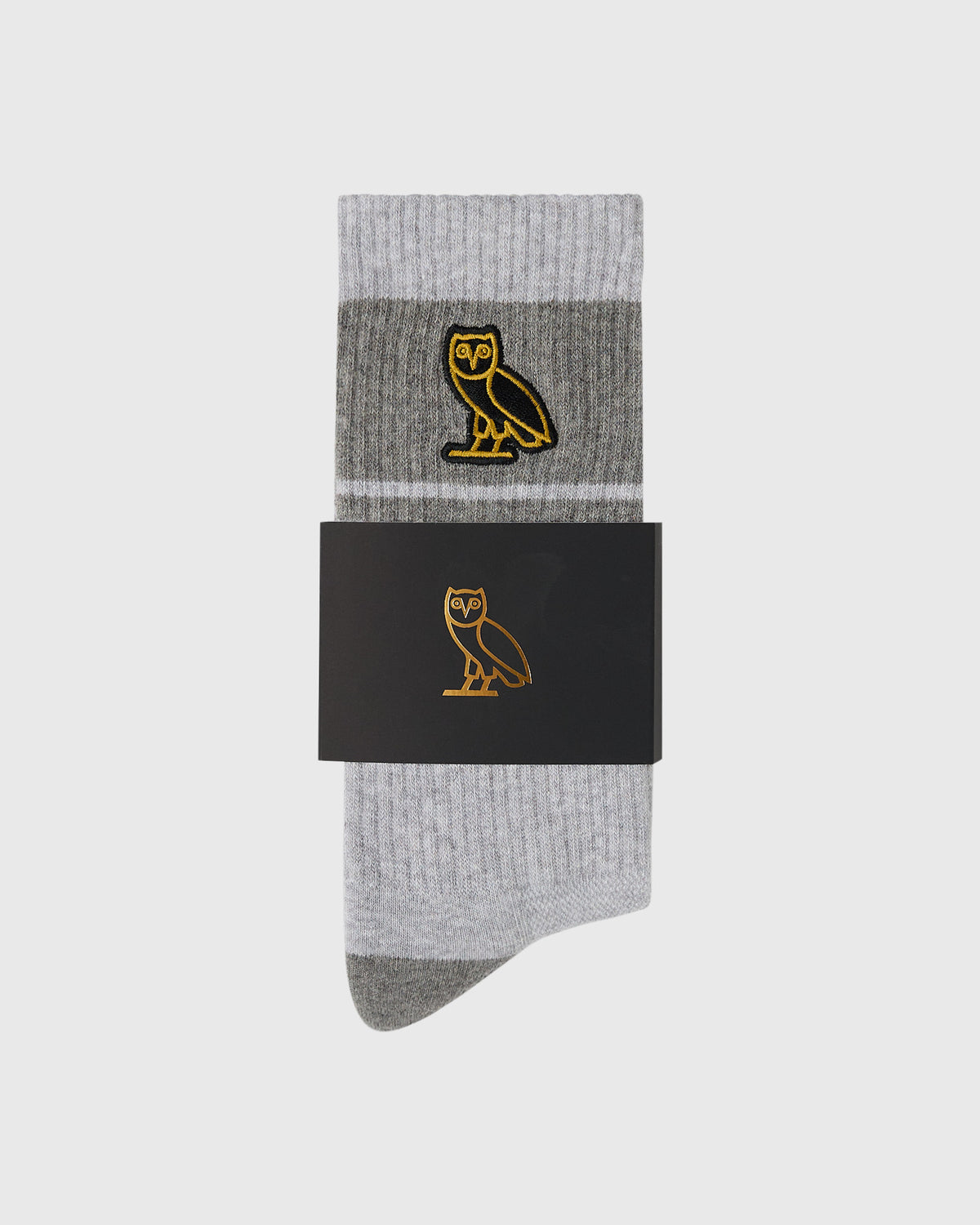 Pair of ash heather grey crew socks with gold owl embroidery and darker grey heel and toe.