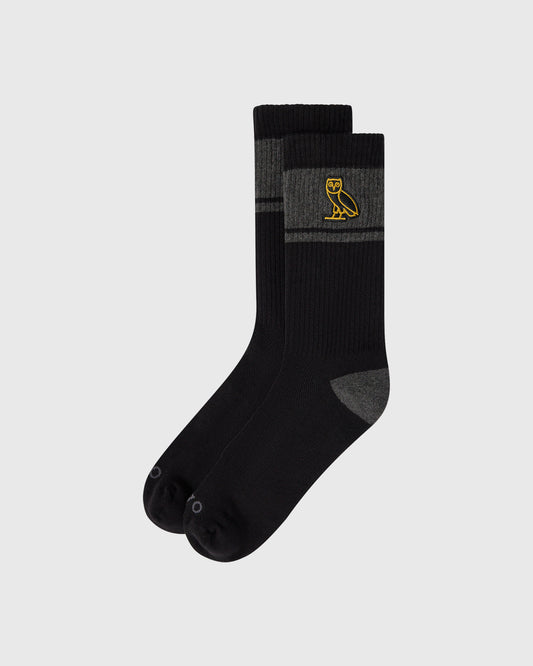 Black crew socks with gray heel and toe accents, featuring a yellow owl logo on the calf.