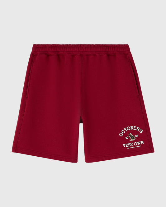Deep red shorts with elastic waistband and side pockets, featuring "October's Very Own" text graphic on right leg.