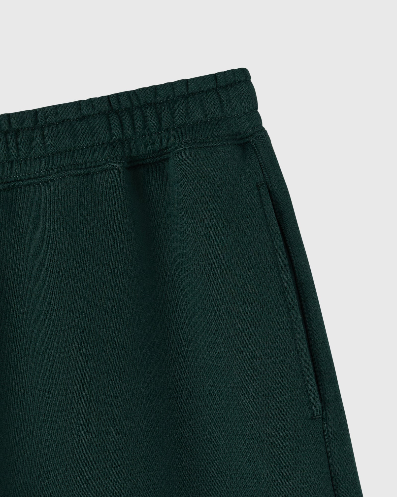Midnight green shorts with elastic waistband and side pocket detail.