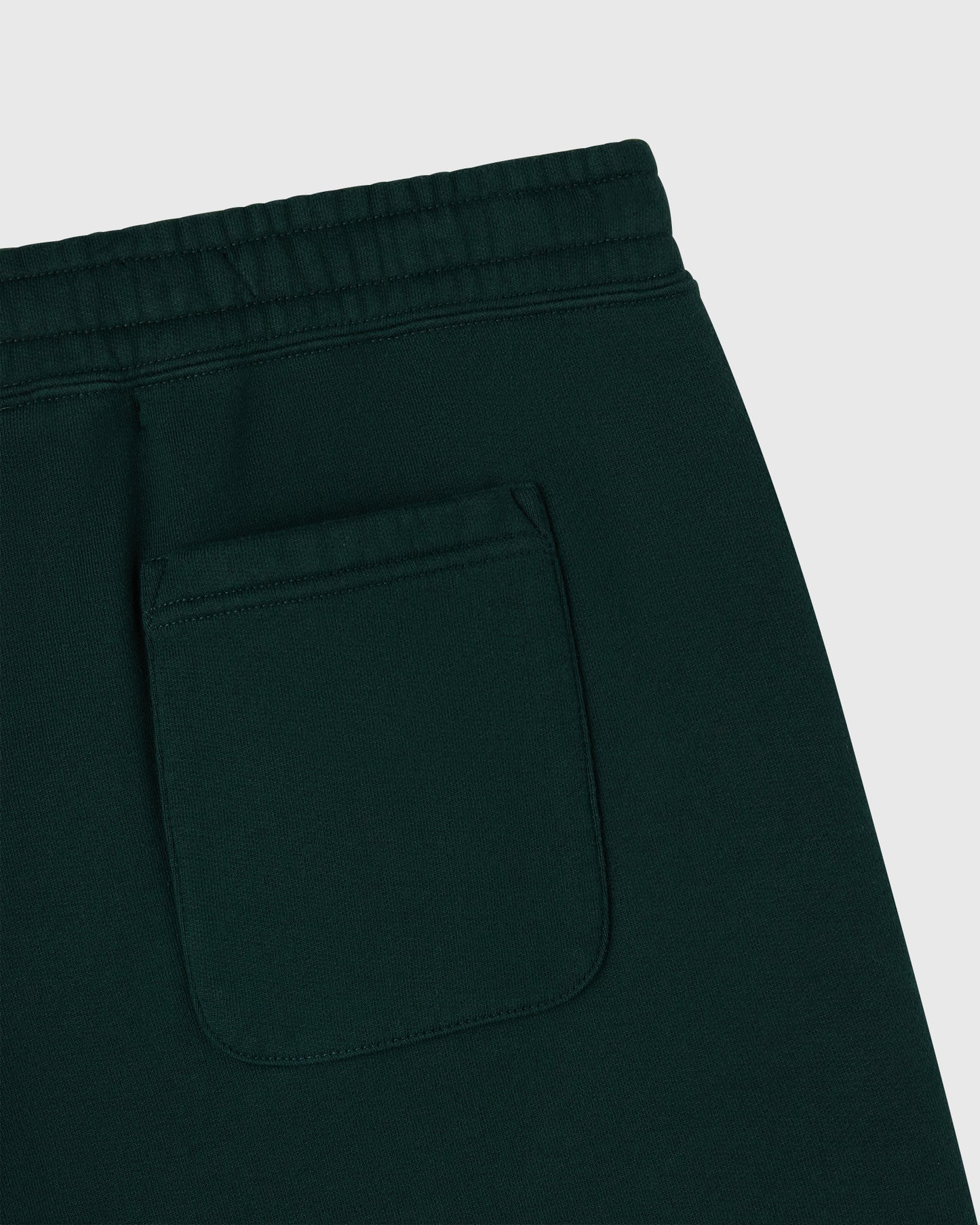 Midnight green sweatpants with elastic waistband and front pocket detail.