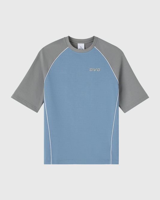 Blue and gray raglan training tee with contrasting short sleeves and white piping detail.