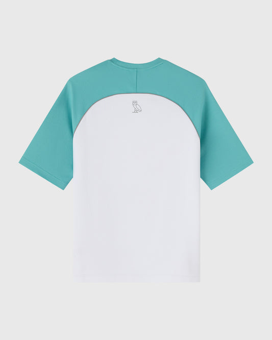 White and teal raglan training tee with small owl logo on back.