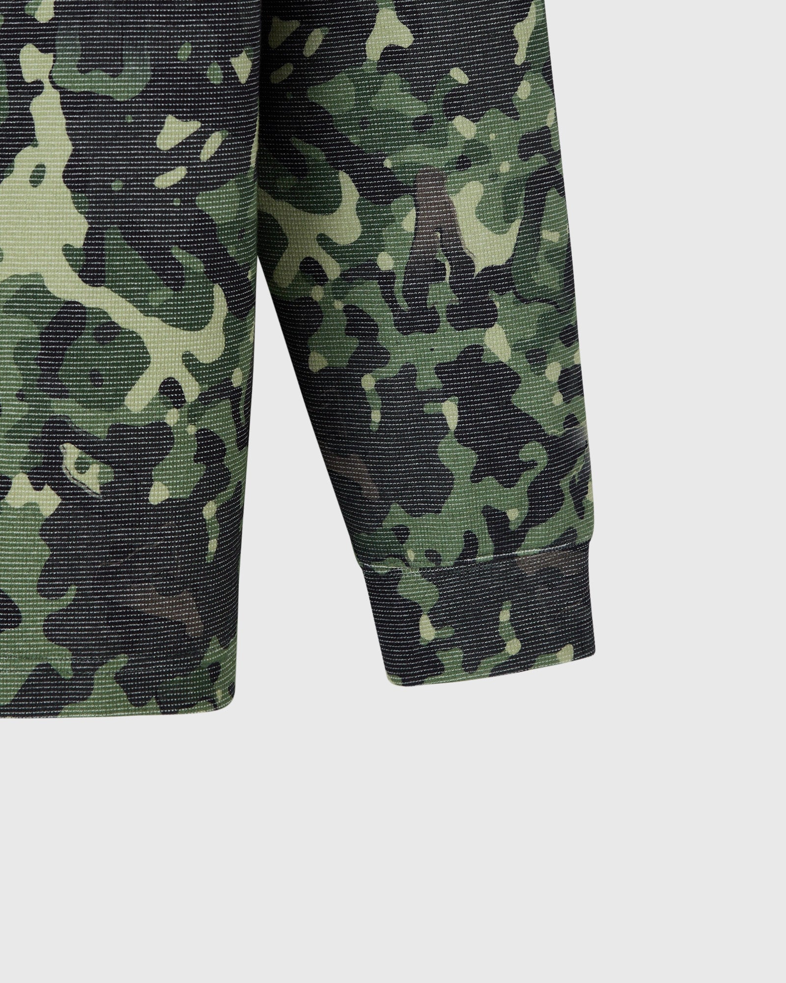 Green and black camouflage long-sleeve tee with textured fabric and ribbed sleeve cuffs.