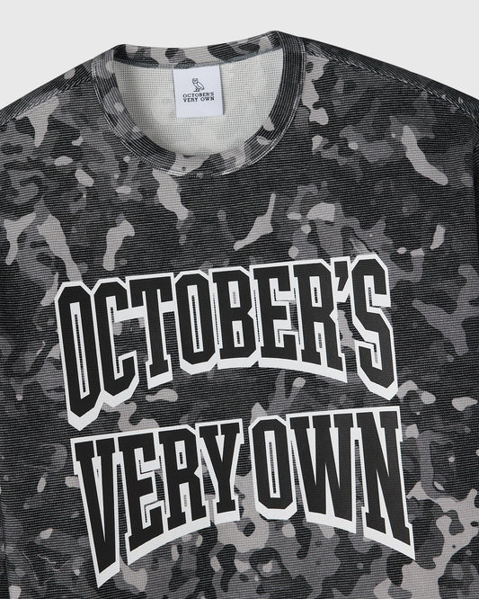 Grey camouflage long-sleeve tee with white "October's Very Own" text graphic on chest.