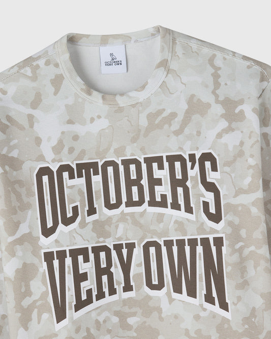 Long-sleeve tee in desert camouflage pattern with brown and white "October's Very Own" text graphic.
