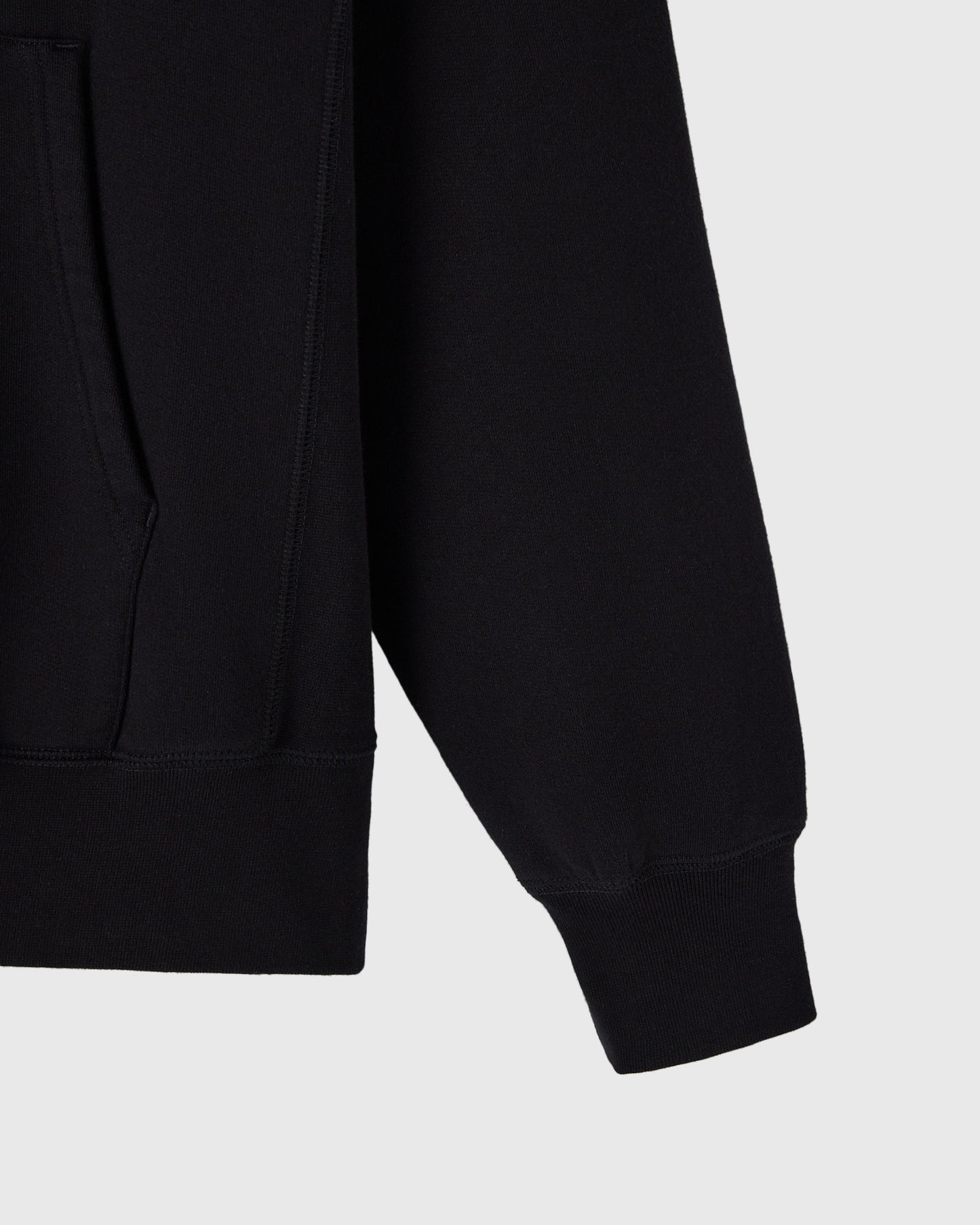 Black hoodie with ribbed cuffs and hem, shown from shoulder and sleeve detail.