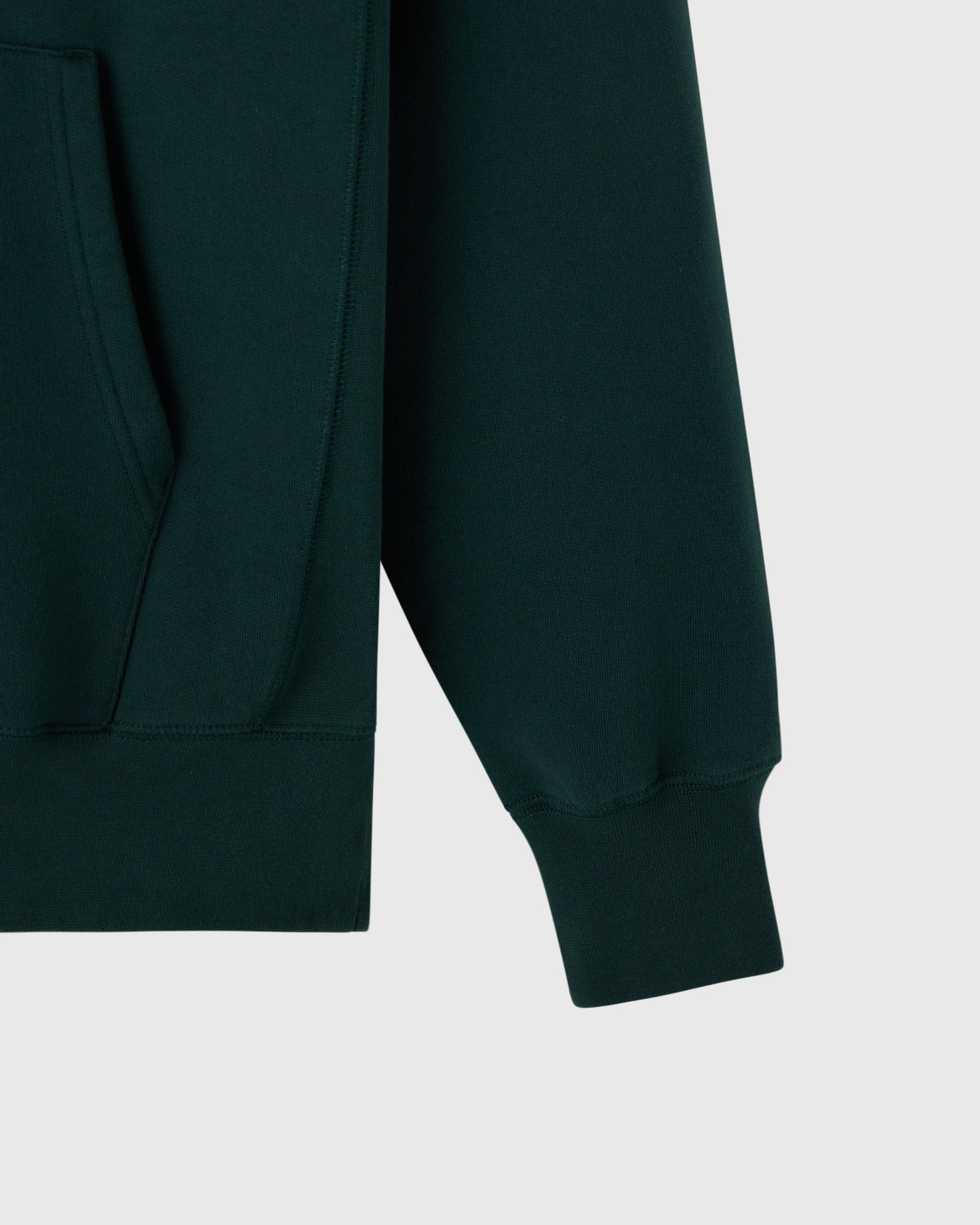 Midnight green hoodie with ribbed cuffs and kangaroo pocket detail visible on front.