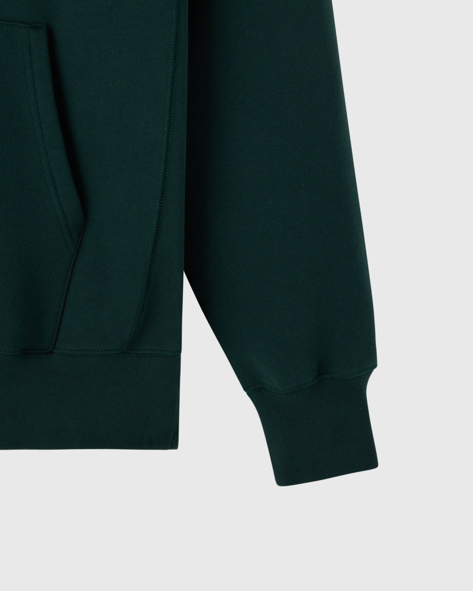Midnight green hoodie with ribbed cuffs and kangaroo pocket detail visible on front.