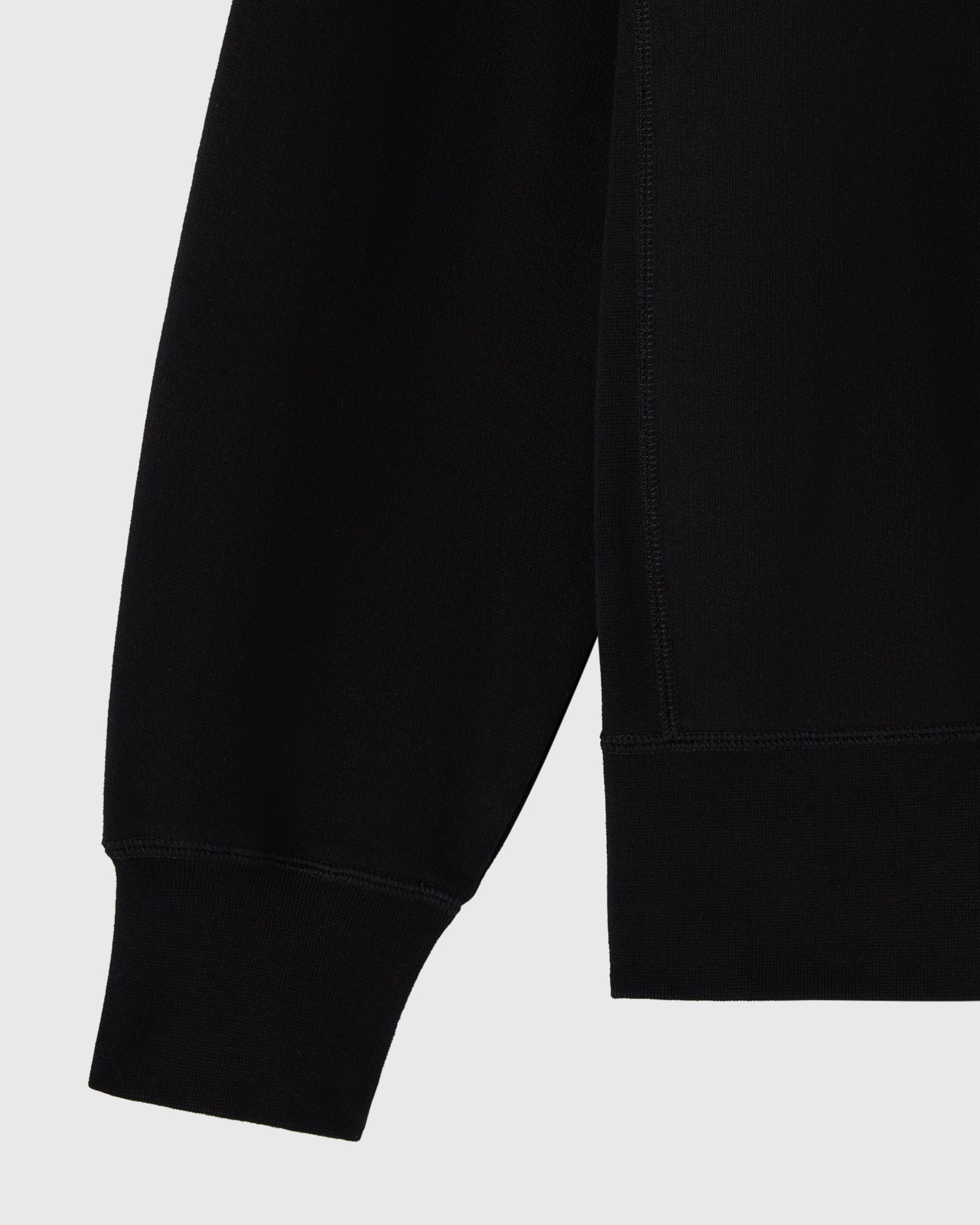Black crewneck sweatshirt with ribbed cuffs and hem detail.