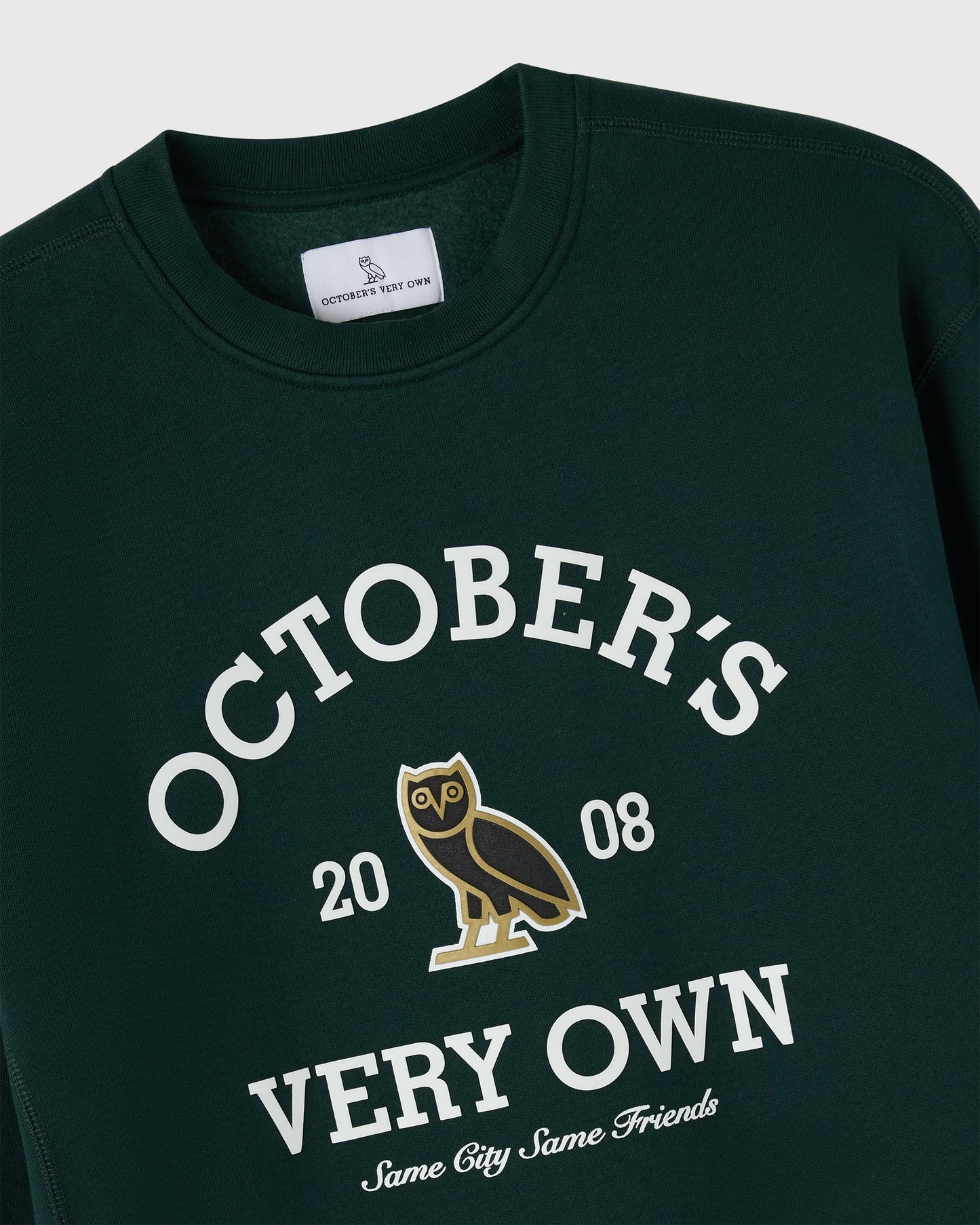 Midnight green crewneck sweatshirt with white "October's Very Own" text, owl graphic, and "2008" print.