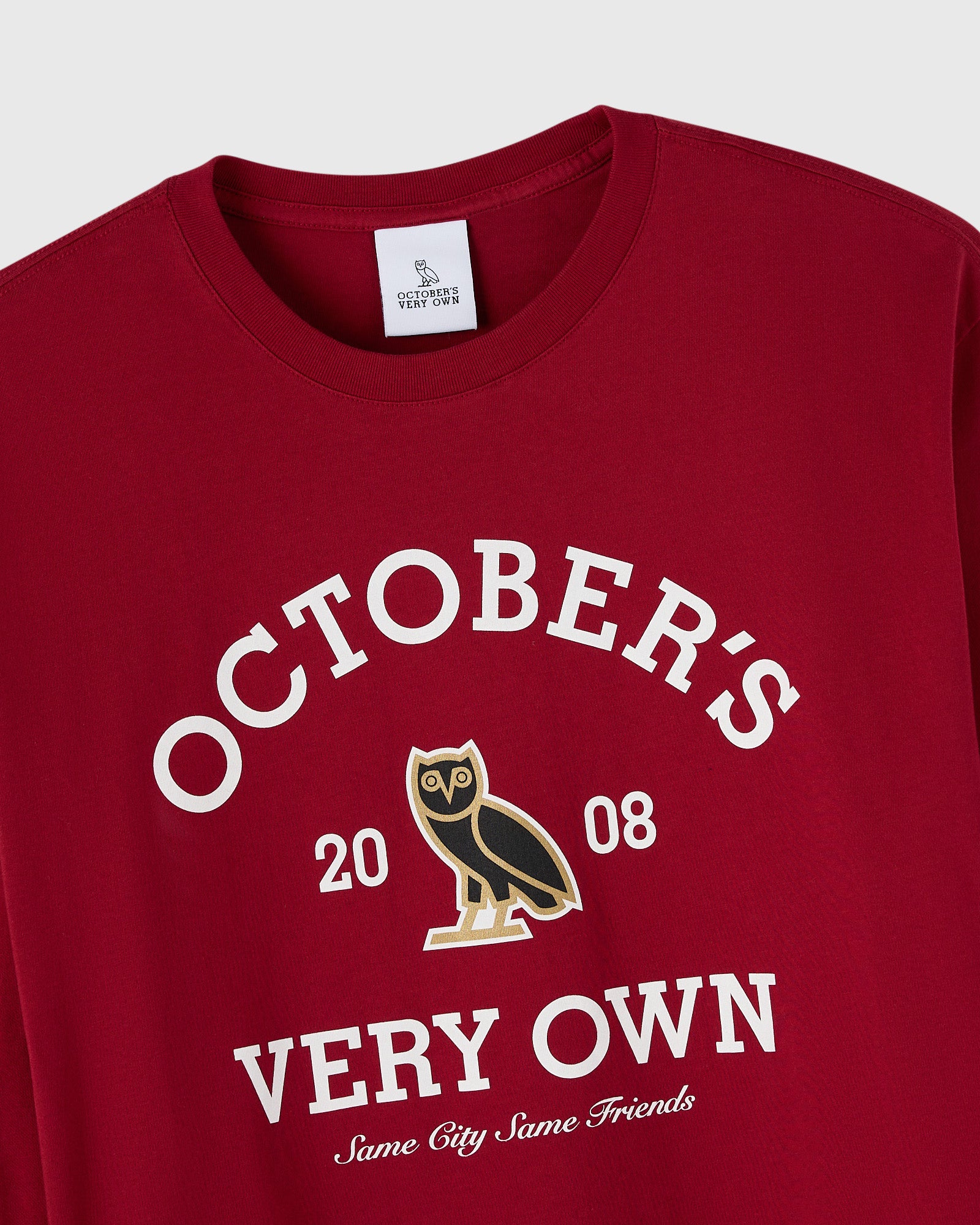 Deep red long-sleeve tee with white "October's Very Own" text, owl graphic, and "2008" and "Same City Same Friends" details.