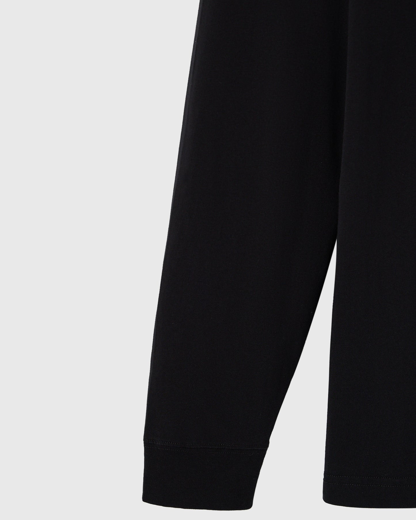 Black long-sleeve tee with ribbed cuffs at the wrists.