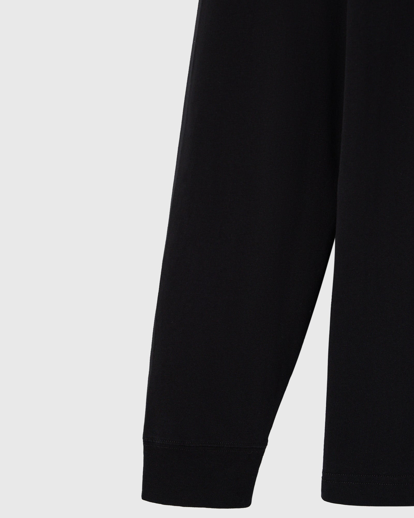 Black long-sleeve tee with ribbed cuffs at the wrists.