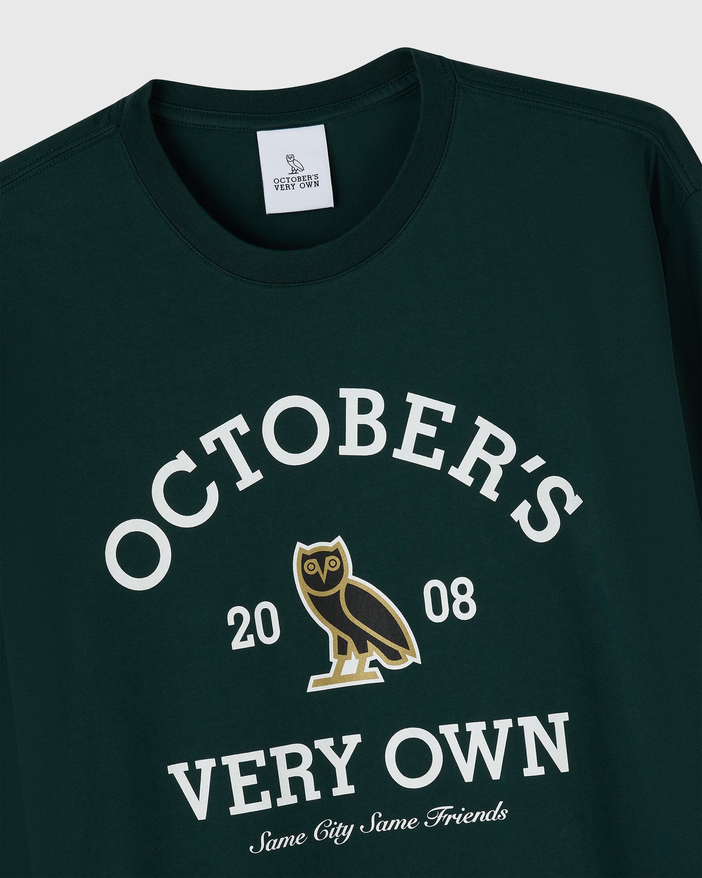Midnight green long-sleeve tee with white text reading "October's Very Own," gold owl graphic, and "20 08" printed on chest.
